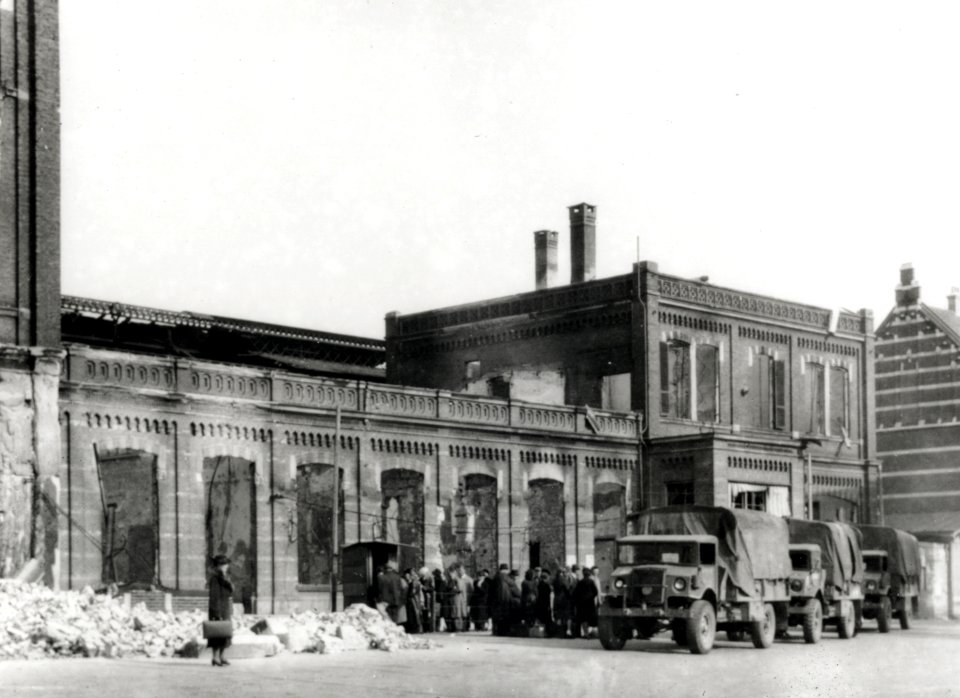 HUA-168057-Gezicht op een gedeelte van het tijdens de oorlog vernielde N.S.-station Arnhem te Arnhem, met vrachtauto's van het Canadese leger die ingezet worden door de N.S. als vervangend vervoer voor treintrei