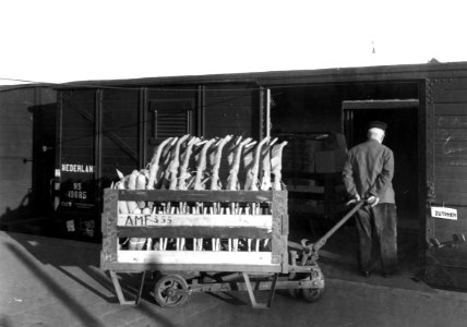 HUA-166320-Afbeelding van het beladen van een gesloten goederenwagen bij de goederenloods van het N.S.-station Amersfoort te Amersfoort