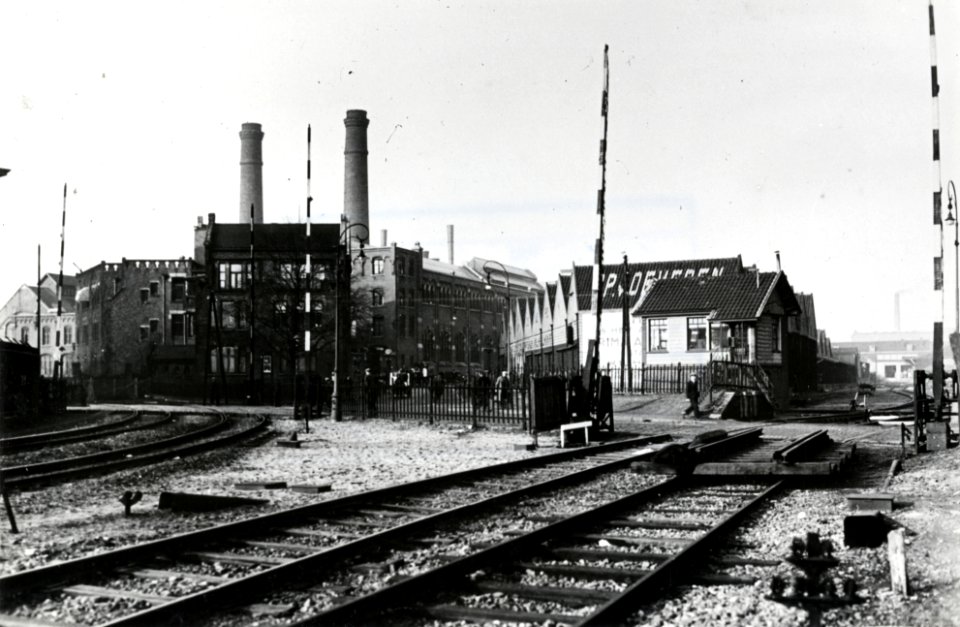 HUA-169357-Gezicht op de spoorwegovergang in de Sarphatistraat te Amsterdam, met naar links de sporen naar het goederenstation aan de Doklaan en rechts de sporen naar de Hoogte Kadijk (goederenenplacement Nieuwe