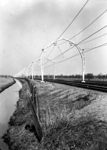 HUA-167146-Gezicht op de spoorlijn bij Maartensdijk, kort na de electrificatie, met de halfronde betonnen bovenleidingsportalen (driescharnierenboog-constructie)