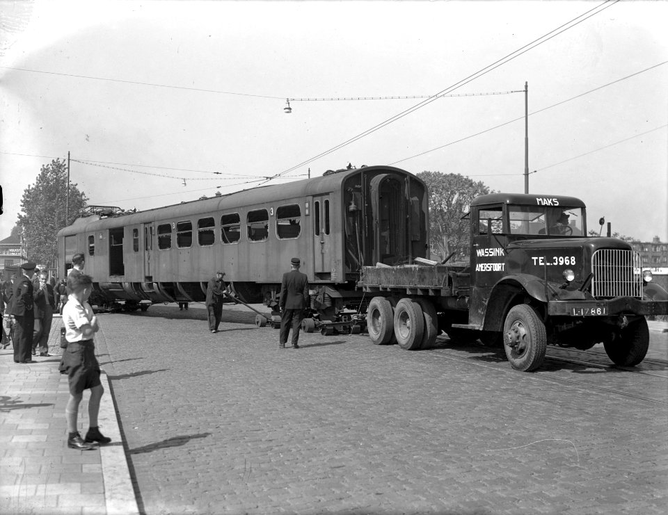 HUA-168060-Afbeelding van het transport van een rijtuigbak van een tijdens de oorlog beschadigd electrisch treinstel mat 1940 nr 305 van de NS per vrachtauto van