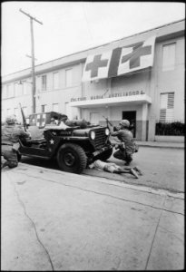 Humanitarian G.I.'s. Firefight where G.I. pushes little kid under jeep for protection, Santo Domingo, May 5., 1965 - NARA - 541806 photo