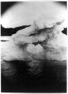 Iceberg or ice formation with hole at center, off the coast of Labrador, with land visible in the background LCCN2012645568