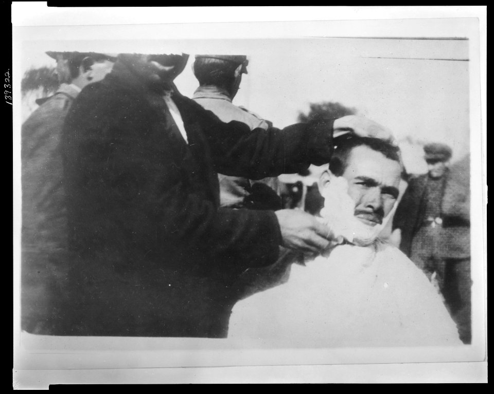 In barbers' row. There are forty of these crude, improvised barber's chairs in a row along the quay in the Piraeus, the sea port of Athens This victim is being shaved. Is (i.e. when) his LCCN2010648498