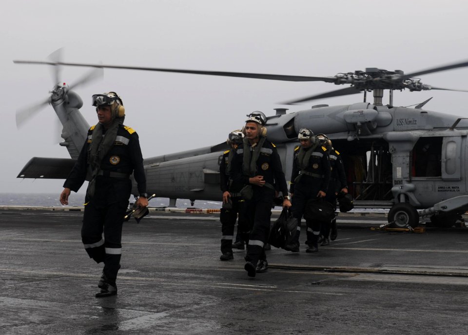 Indian Navy Rear Admiral Biswajit Dasgupta, flag officer commanding eastern fleet, transits the flight deck of the aircraft carrier USS Nimitz (CVN 68) after arriving aboard via an MH-60R Seahawk helicopter
