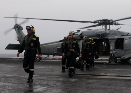 Indian Navy Rear Admiral Biswajit Dasgupta, flag officer commanding eastern fleet, transits the flight deck of the aircraft carrier USS Nimitz (CVN 68) after arriving aboard via an MH-60R Seahawk helicopter