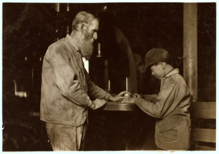Indiana Mfg. Co. Peru, Ind. The old and the new. Old man has been there 33 years. Boy starting in, working with a board saw. LOC nclc.04486