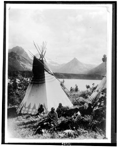 Indian with two tepees beside a lake in Rocky Mountain National Park, Colorado LCCN90709619