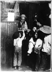 Indianapolis Newsboys buying brass checks in a newspaper office. These checks cost at the rate of one-half the... - NARA - 523074