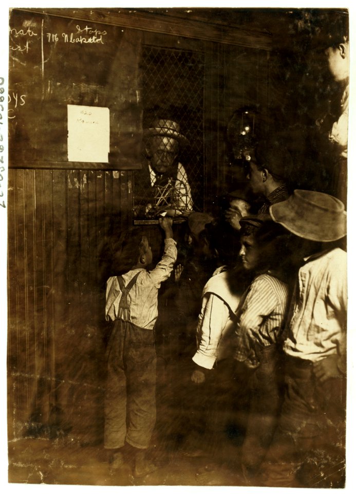 Indianapolis Newsboys buying brass checks in a newspaper office. These checks cost at the rate of one-half the selling price of the newspaper and are exchanged at another window for the LOC cph.3c05660