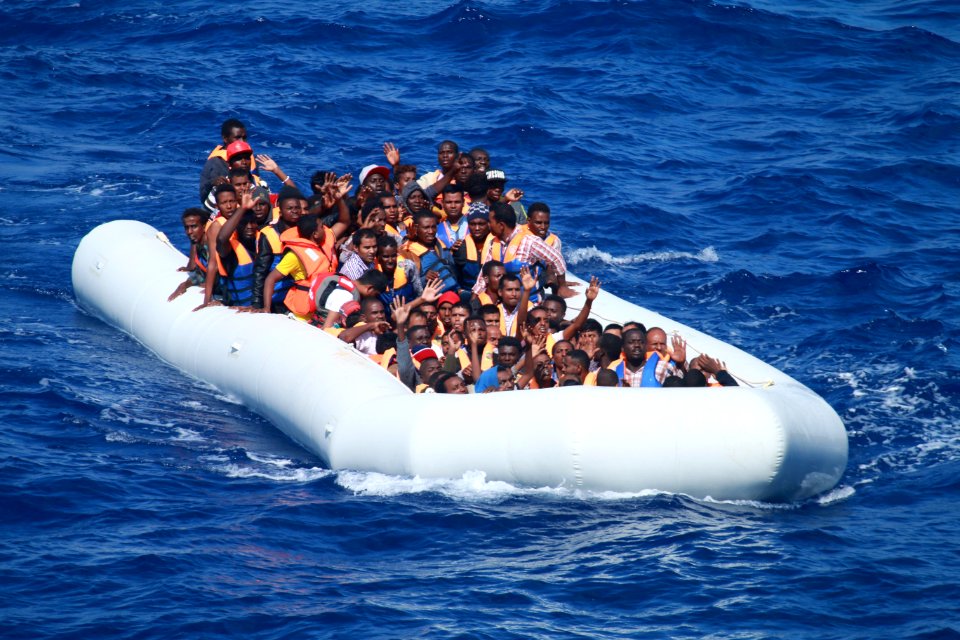 Inflatable boat carrying migrants approaching USS Carney (DDG-64) in the Mediterranean 160729-N-EU999-004