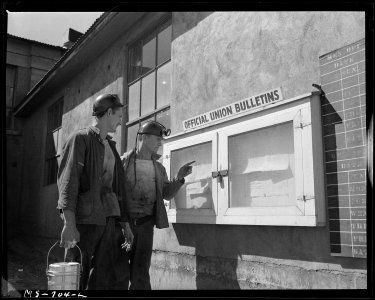 J. M. Hawkins (left) former pharmacists mate in the U.S. Navy and Wm. Smith, former Marine, read notice on the... - NARA - 540561