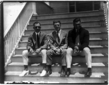 Jack Dempsey at his training camp, June 1921- seated on porch steps with 2 men LCCN2005681068