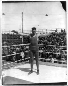 Jack Dempsey at his training camp, June 1921- standing in ring with arms spread wide LCCN2005681074