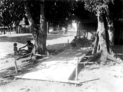 Kvinnan som väver syns i bakgrunden. Byn Ambato, nordvästra delen av ön, Madagaskar. Ambato - SMVK - 001740
