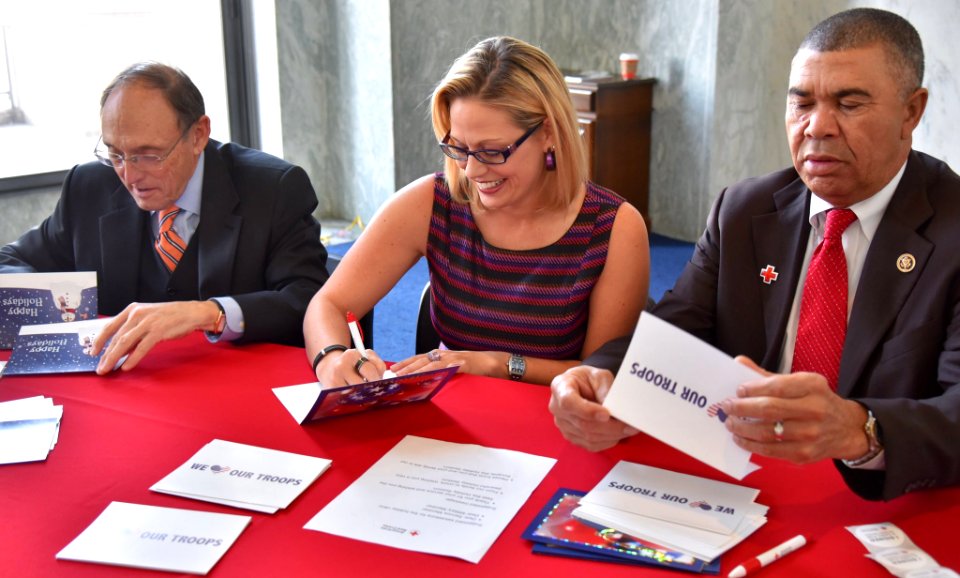 Kyrsten Sinema signing holiday cards for troops in 2016. 02