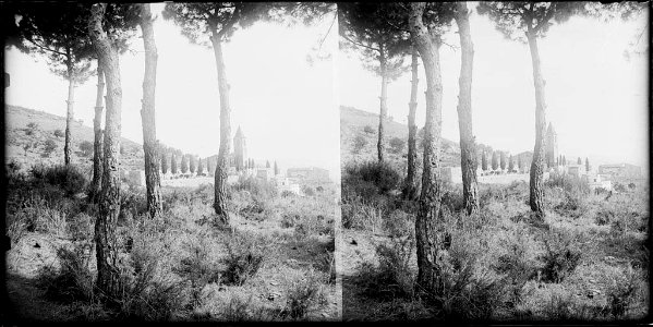 L'església de Sant Genís dels Agudells amb uns arbres en primer terme