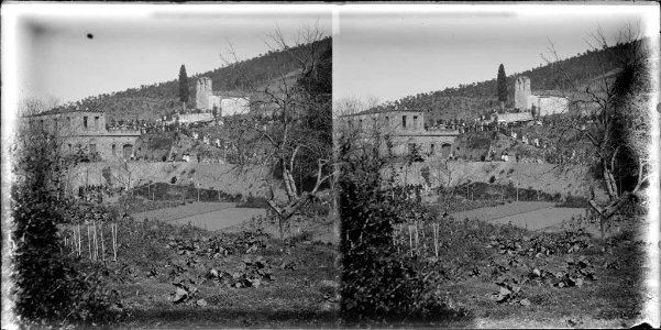 L'ermita de Sant Medir amb gent al voltant i alguns cases i conreus
