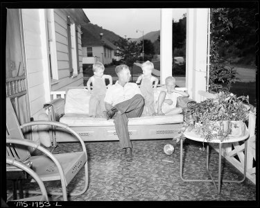 James Jasper, motor brakeman, with his three children on front porch of their home in company housing project.... - NARA - 540915