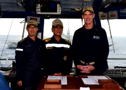 JMSDF Rear Admiral Yoshihiro Goka, Indian Navy Rear Admiral Biswajit Dasgupta, and U.S. Navy Rear Adm. Bill Byrne pose for a photo in primary flight control aboard the USS Nimitz (CVN 68) during Malabar 2017