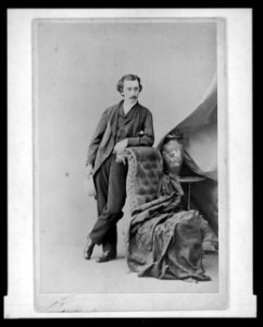 John Bishop Putnam, full-length studio portrait, facing slightly right, leaning on chair LCCN2004681715