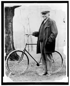 John D. Rockefeller, full-length portrait, standing with a bicycle LCCN2006691469