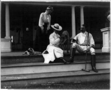 John Drew, 1853-1927, full length portrait, seated on porch step, facing left; with wife, Josephine (Baker) and daugher Louisa Drew and 3 dogs at cottage Kyalami, Easthampton, L.I.; LCCN2005686757