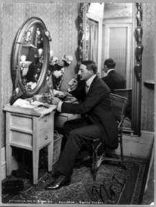 John Drew, 1853-1927, full length, seated at dressing table, facing left; in Empire Theatre LCCN2005683748