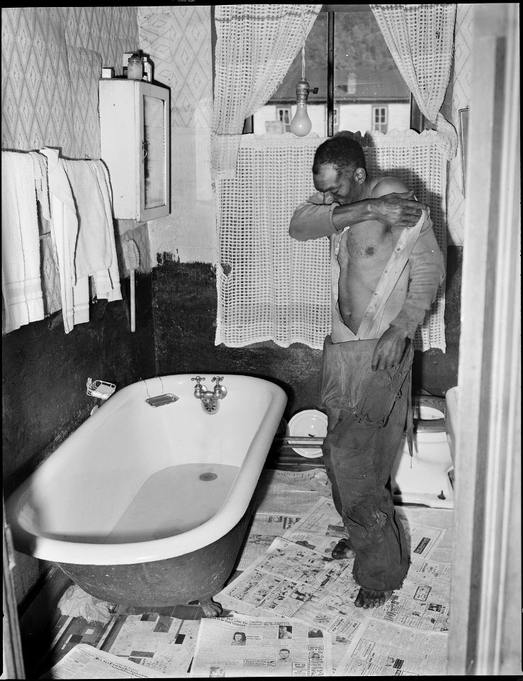 John R. Blaney, coal leader, undresses to take his bath. His is the only bathroom in ... camp. He has been with... - NARA - 540937