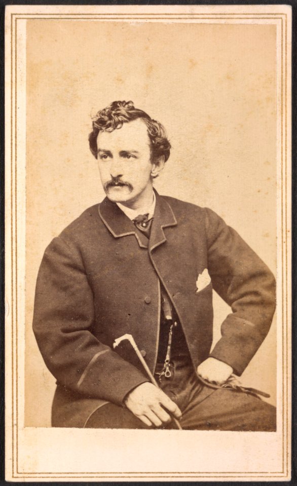 John Wilkes Booth seated, with cane in hand) - Silsbee, Case & Co., photographic artists, 299-1-2 Washington Street, Boston. Case & Getchell, from Dec. 3, 1862 LCCN2015648995
