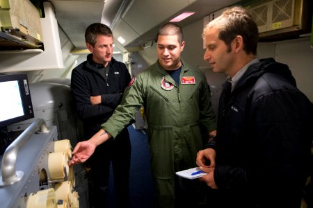 Jon Donnison, left, a journalist with BBC News, and Nicolas Perpitch, right, a journalist with The Australian, speak with U.S. Navy Naval Aircrewman (Operator) 2nd Class Julio Cerpa, assigned to Patrol 140404-N-VD564-060