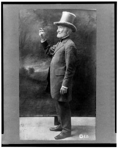 Joseph Cannon, full-length portrait, standing, facing right, wearing top hat and holding up cigar LCCN2002722542