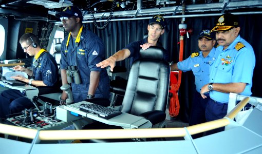 Joseph Gagliano, commanding officer of USS Independence (LCS 2) describes state-of-the-art features of the bridge during a ship tour for Rear Adm Ajendra B. Singh and Commodore Alok Bhatnagar from the Indian navy during RIMPAC 2014
