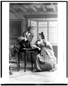 Joseph Jefferson, full-length portrait, seated on table, facing right, looking at a woman LCCN92514228