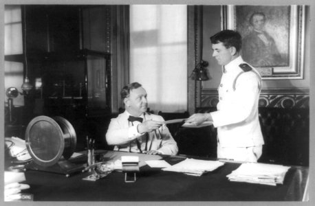 Josephus Daniels, half-length portrait, seated at desk, facing right, and aide Joseph Daniels standing alongside LCCN89709656