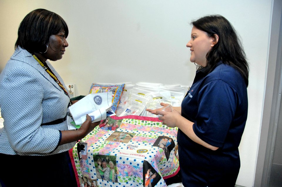 Joyce Scott of Severn, Md., left, chats with Armed Services YMCA staffer, Jennie Mixon, right, about the organization’s Kid Comfort program DVIDS340821