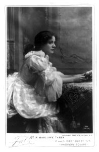 Julia Marlowe Taber, three-quarters length portrait, seated at table, facing right LCCN2005683730