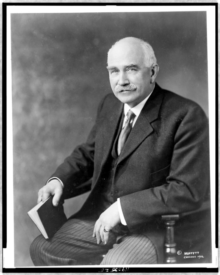 Judson Harmon, three-quarter length portrait, seated, facing left, holding book LCCN97518435