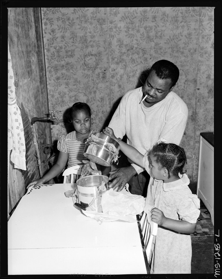 Julius Brooks and his daughters admire new lunch pail. He installed running water in his kitchen at no cost to the... - NARA - 540737