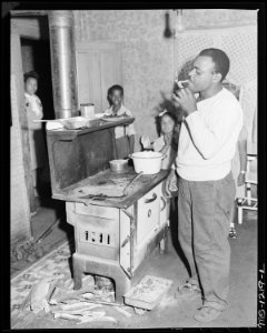 Julius Brooks, miner, in kitchen of his four room house for which he pays $10 monthly. Three adults and three... - NARA - 540738