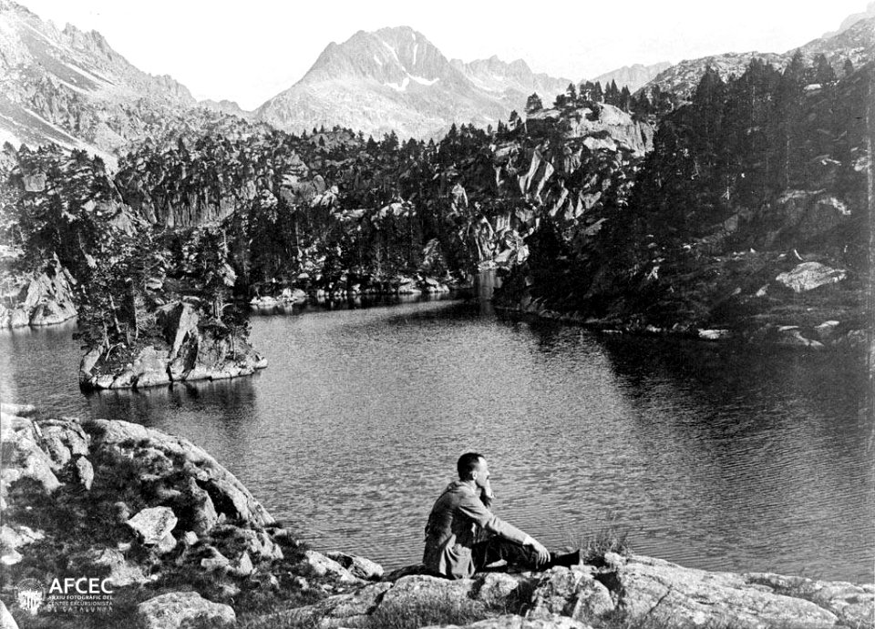 Juli Soler assegut a l'Estanh Long de Colomèrs, amb el tuc de Ratera al fons (AFCEC SOLER C 0034)