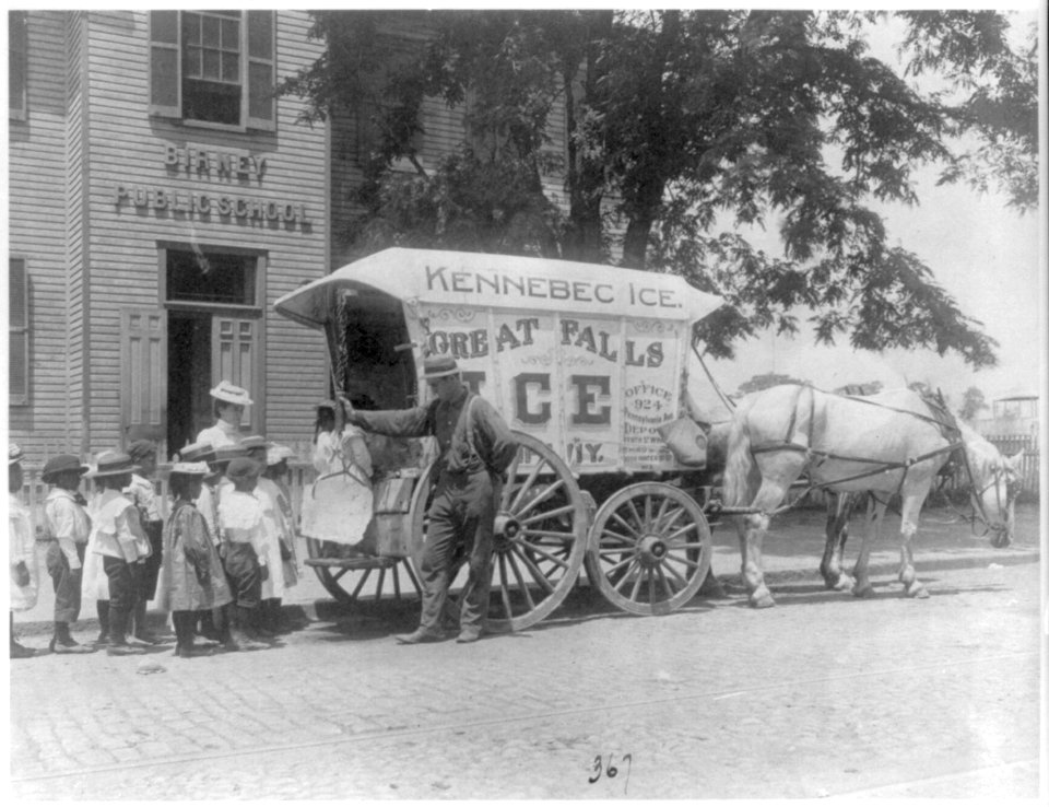 Kennebec Ice horse-drawn wagon parked in front of Birney Public School - school children lined up with teacher behind wagon as man shows them large chunk of ice suspended by tongs, LCCN2001702335