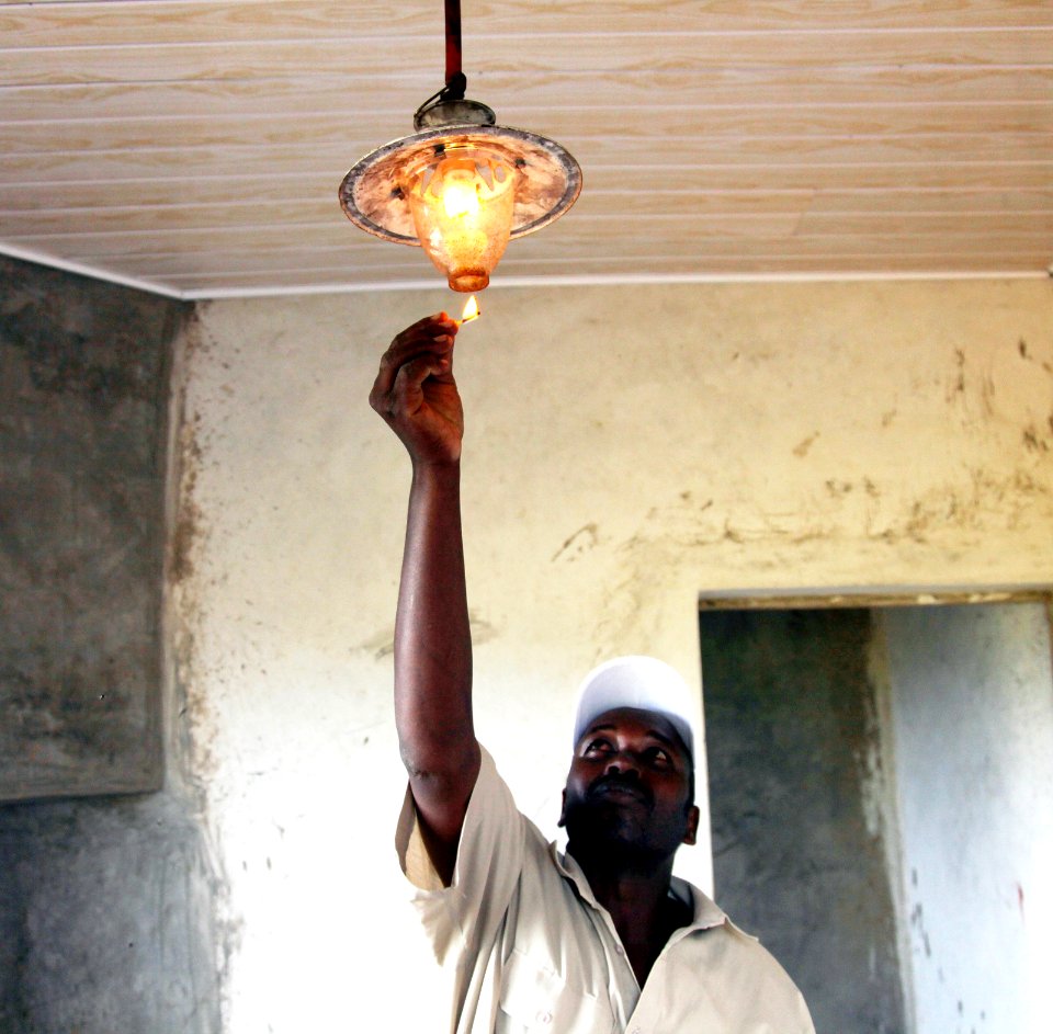 Kenyan farmer with a biogas lamp provided by USAID 2013