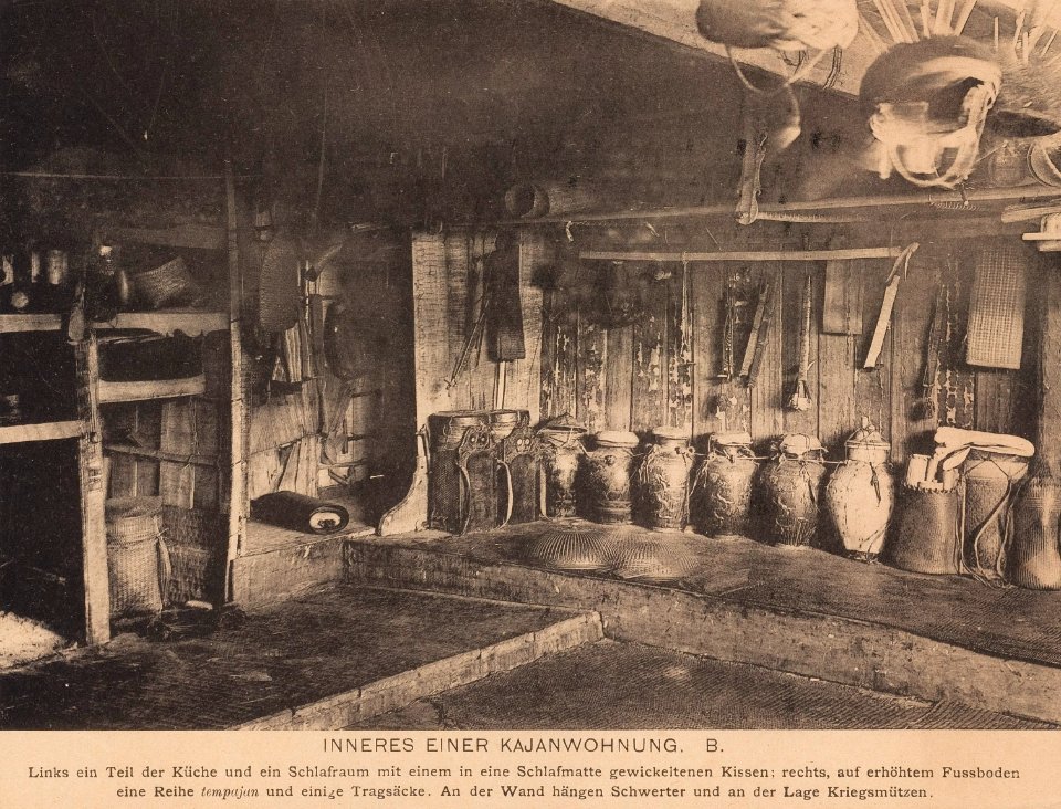 KITLV - 173527 - Demmeni, Jean (1866-1939) - Kayan interior of a house in Borneo, with a kitchen, a bedroom, a row of tempajan (tempayan) vessels, swords and war caps - Collotype - 1890-1904