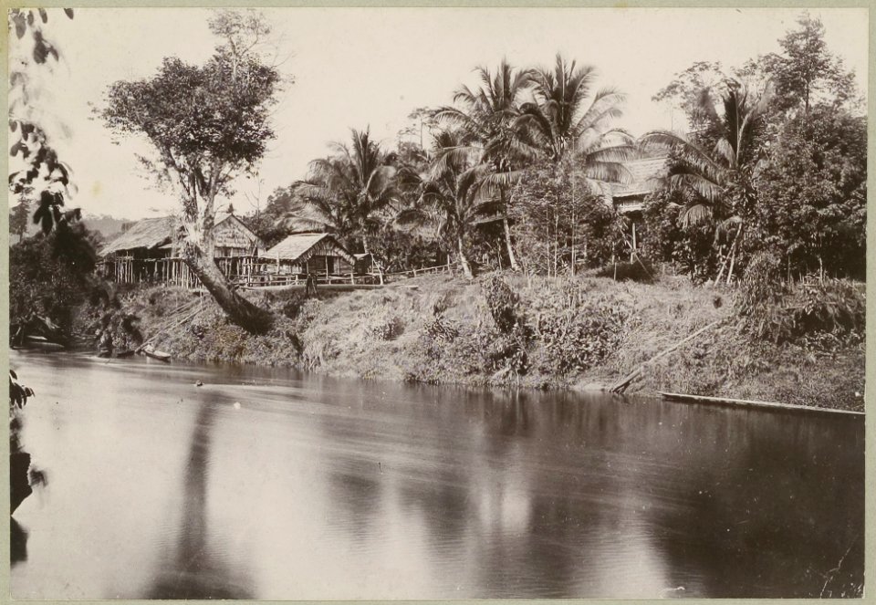 KITLV - 25660 - Demmeni, J. - The establishment of Kwing Irang on the Bloeoe River, Central Borneo. The cabin of the expedition behind the ramp in the center - 1896-1897