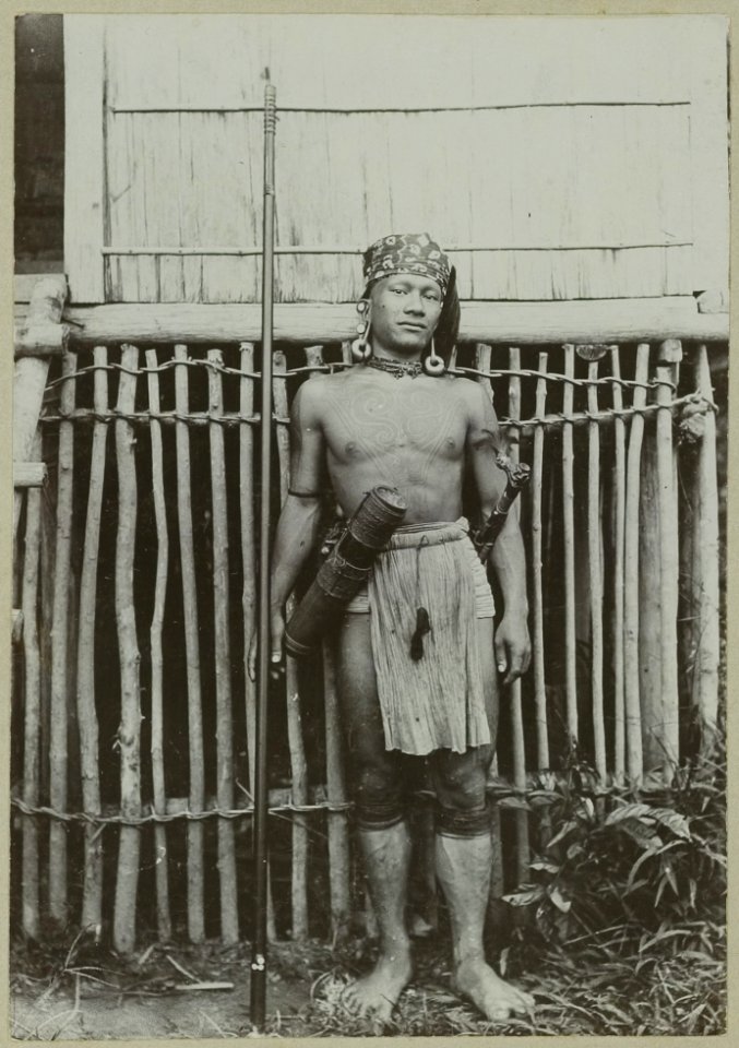 KITLV - 25672 - Demmeni, J. - Head of the Boekats the Samoes, affluent of the Kapuas River (Sungai Kapuas), north of Putus Sibau. Tattoo on his chest and upper arms, ears pierced several times and mirror controls it put - 1896-1897