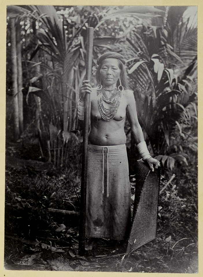 KITLV - 25788 - Demmeni, J. - Bo Ino, a wealthy woman of Bloeoe River Kayans with rice pestle and wan, Upper Mahakam, Central Borneo - 1896-1897