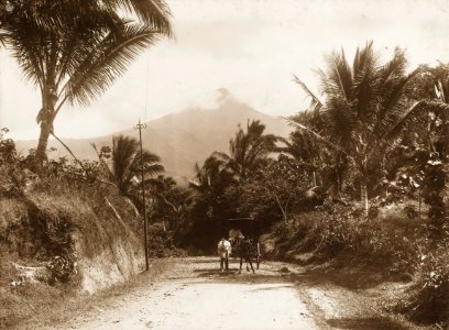 KITLV - 158780 - Kurkdjian - Sourabaia-Java - Coach on a road in the Minahasa with volcano Mount Klabat in the background - circa 1900