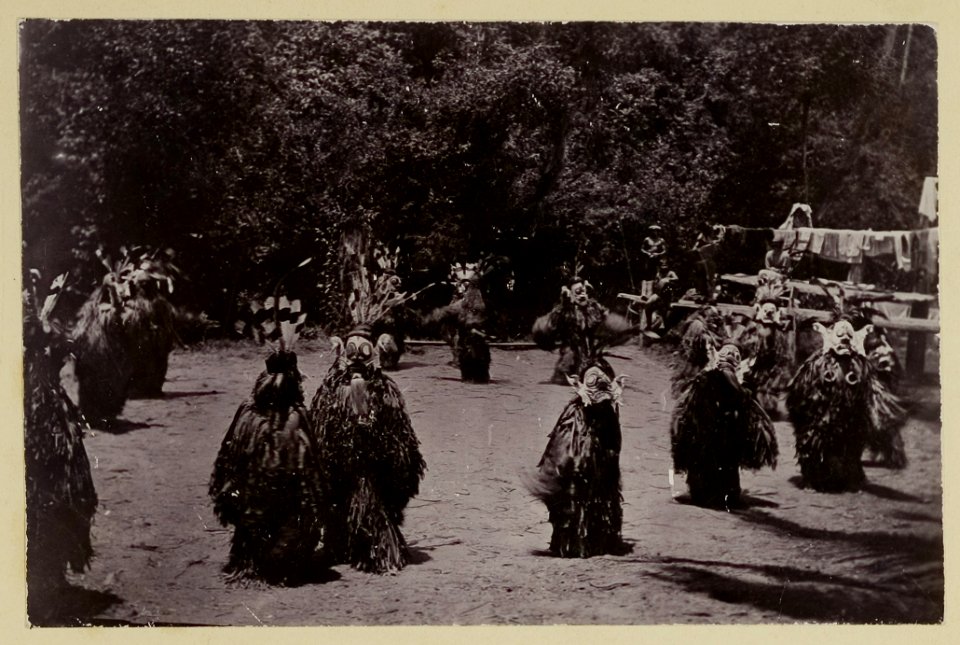 KITLV - 25784 - Demmeni, J. - Mask Dance of Kayan men on the Bloeoe River, Upper Mahakam, Central Borneo, on the occasion of the seed sowing festival. The entire body is covered with frayed Pinang palm leaves - 1896-09-01