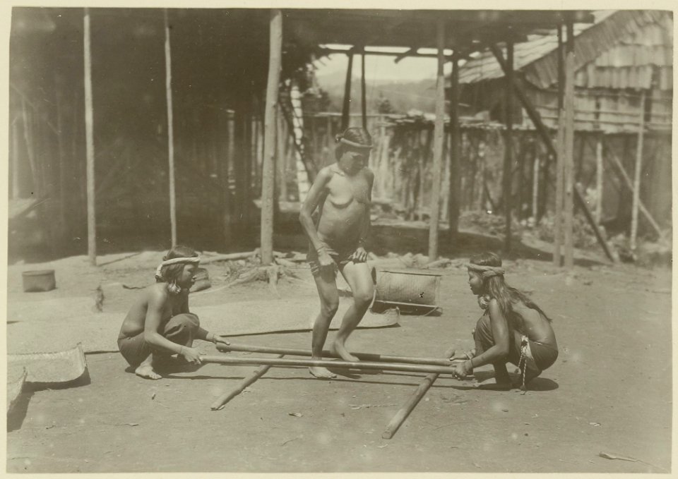KITLV - 25689 - Demmeni, J. - Kayan woman dancing on a specific beat between rice pistils (kang kep). Upper Mahakam, Central Borneo - 1898-1900